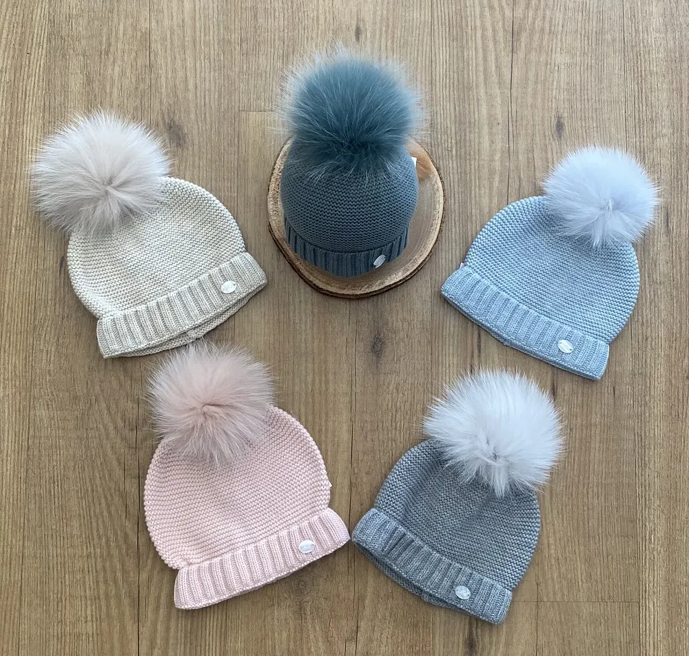 Chubby knit hat in various colors. It wears a natural fur pompom.