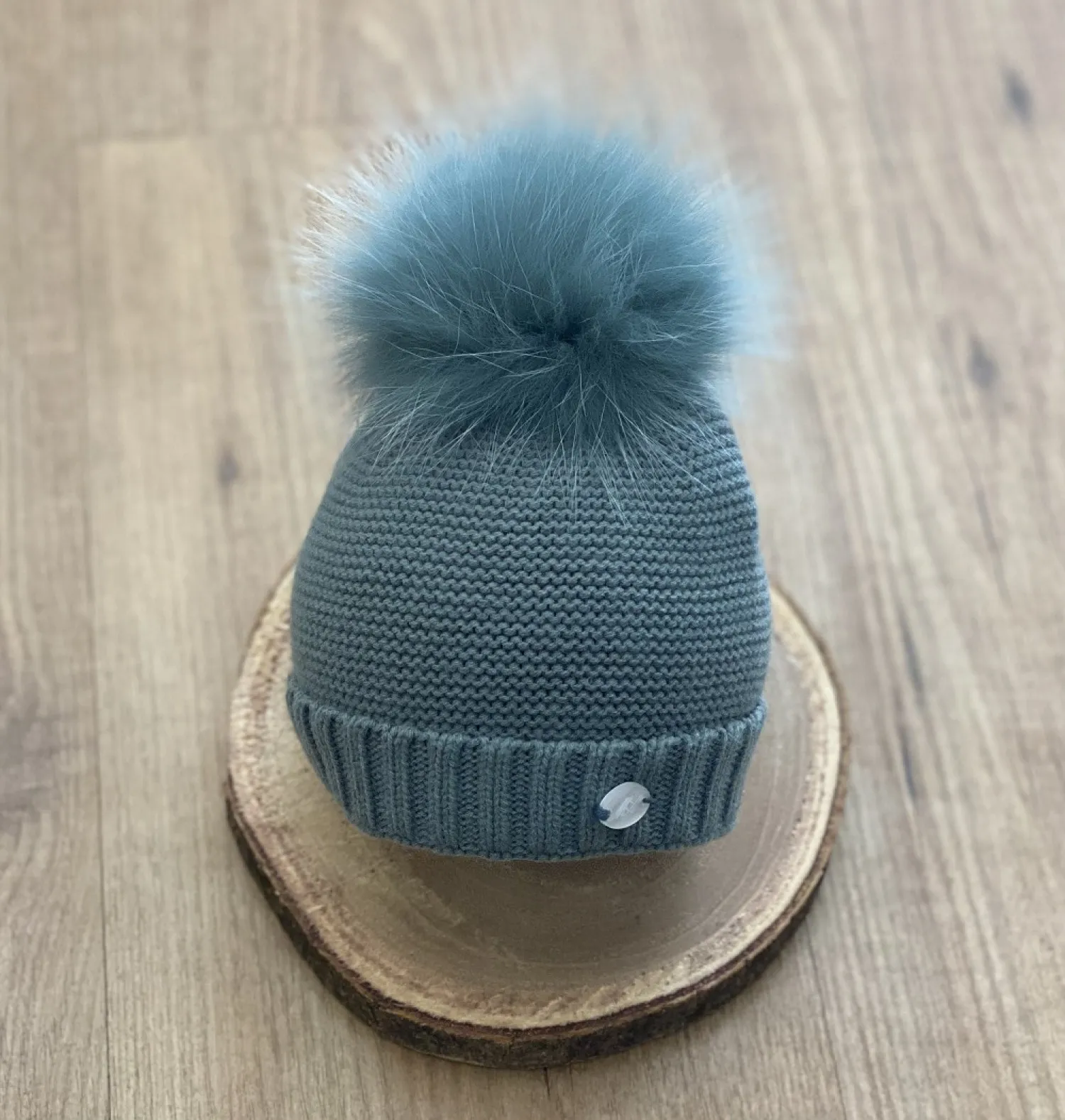 Chubby knit hat in various colors. It wears a natural fur pompom.