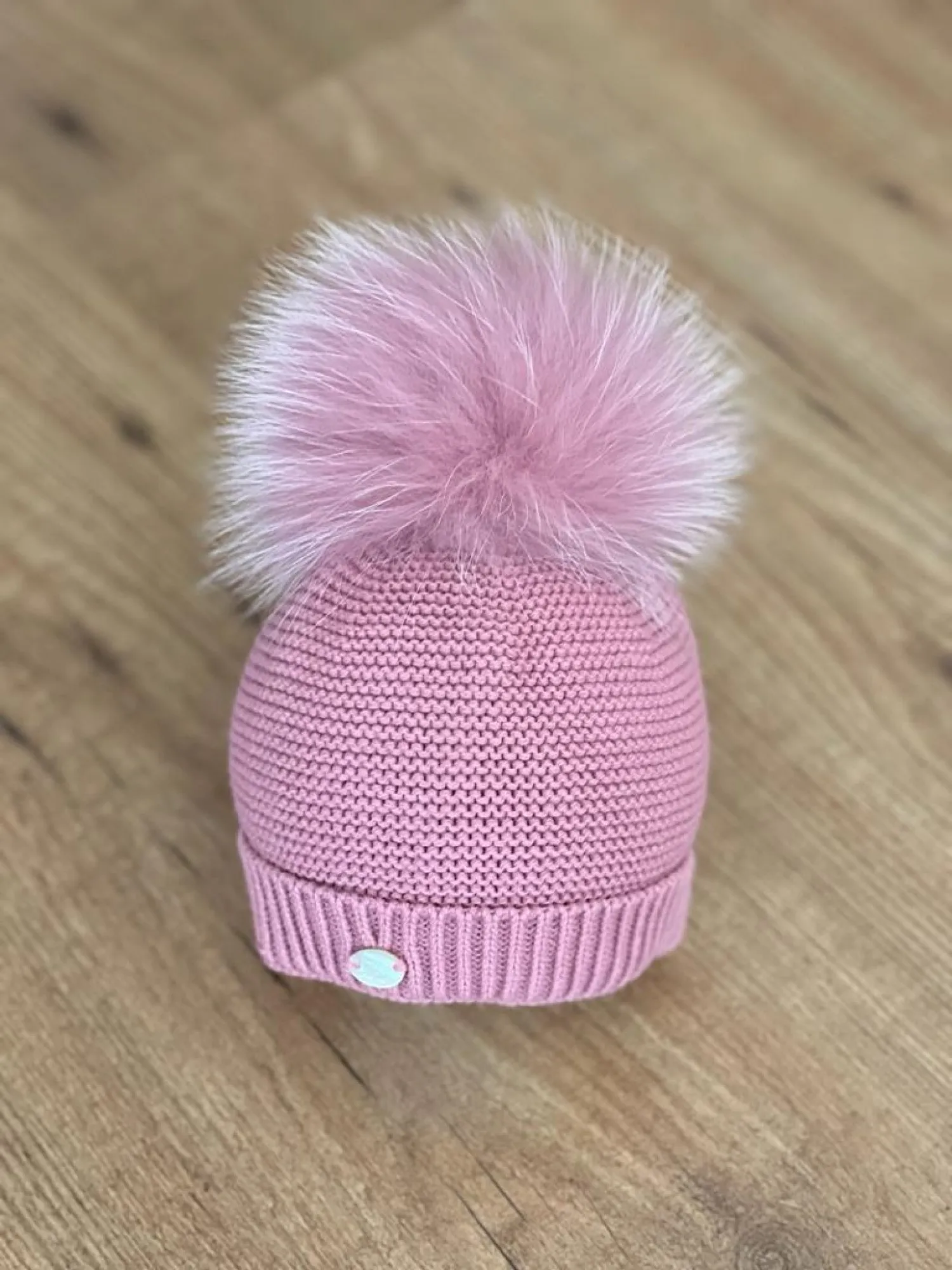 Chubby knit hat in various colors. It wears a natural fur pompom.