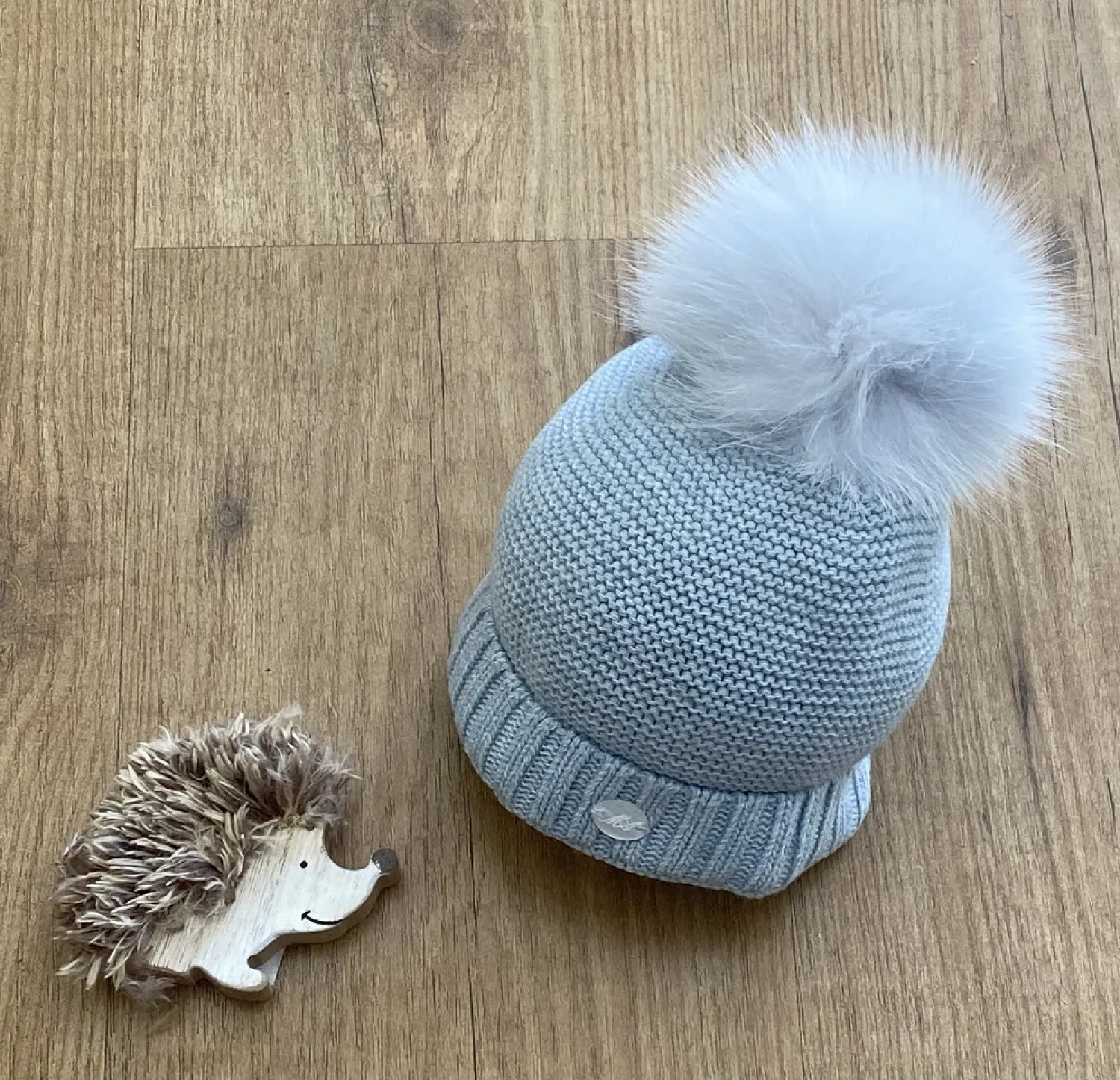 Chubby knit hat in various colors. It wears a natural fur pompom.