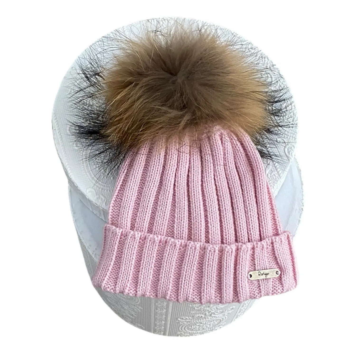 Ribbed hat in various colors. She wears a hair pompom.